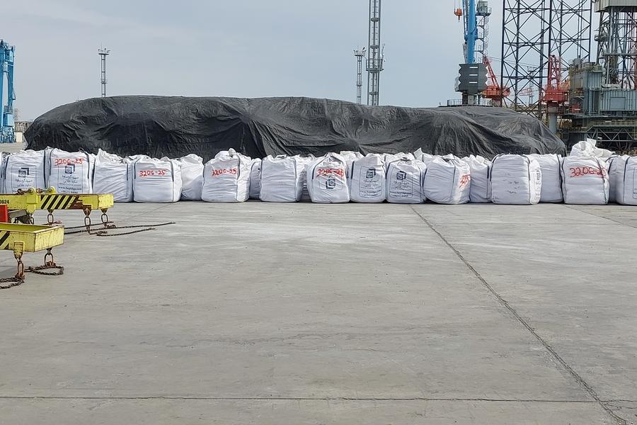 Bagged cargo kept under tarpaulin cover on the quay